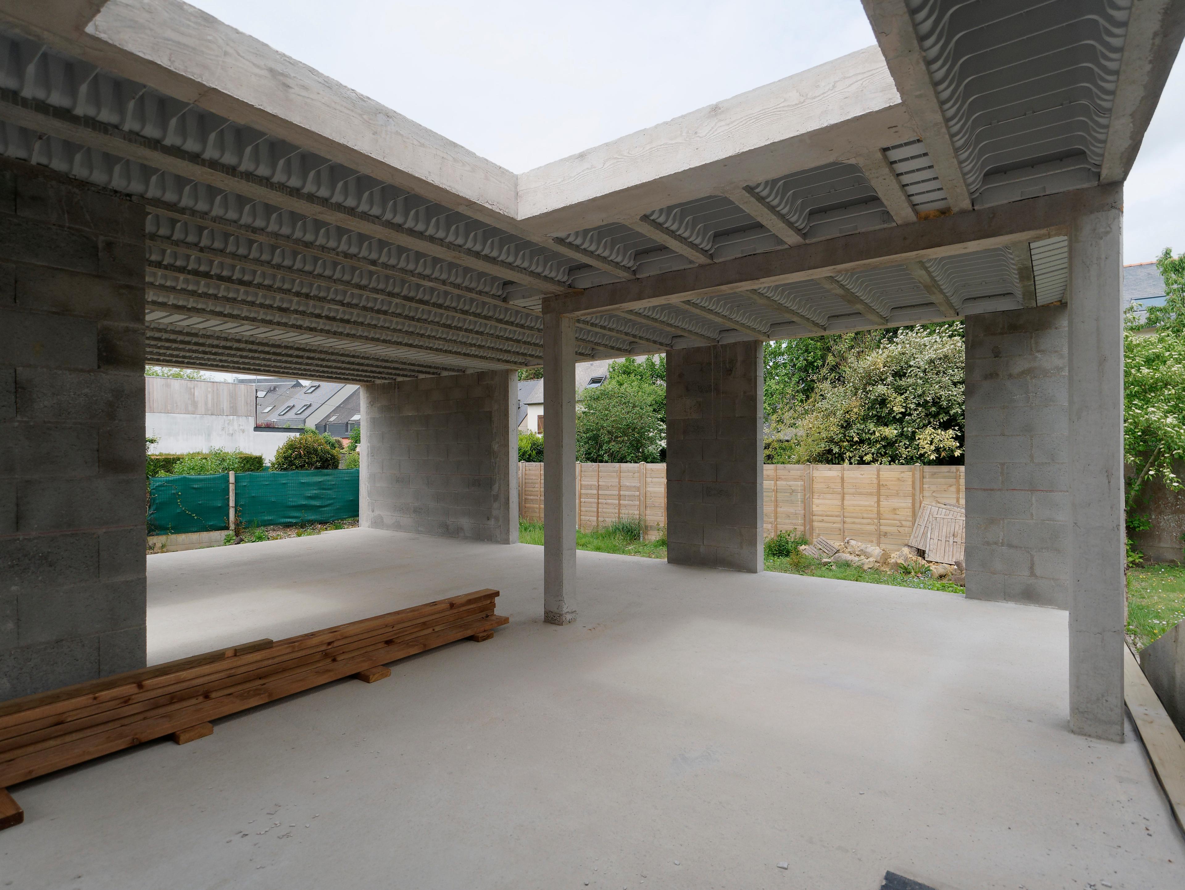 Chantier en cours : Rez-de-chaussée, poteaux, poutres, planchers en béton armé.